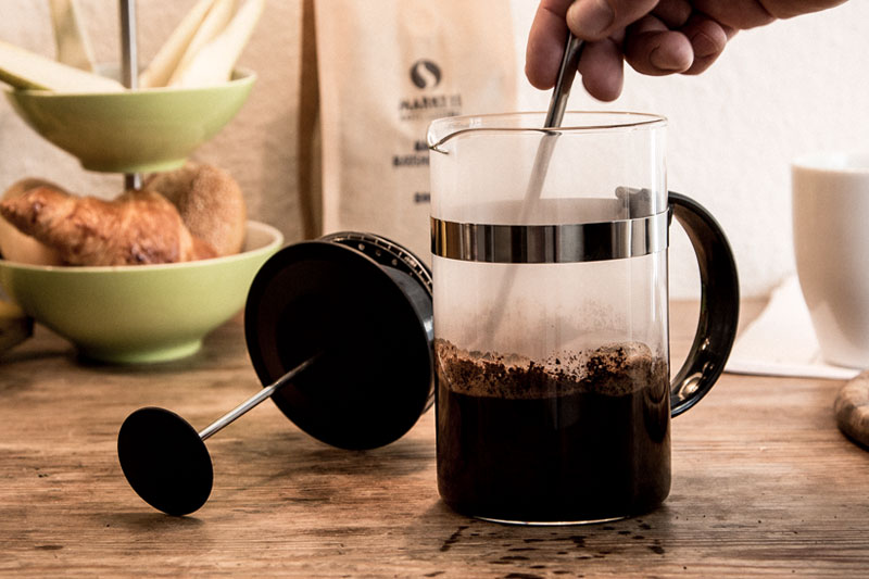 Erst das Kaffeepulver mit Wasser bedecken und umrühren.